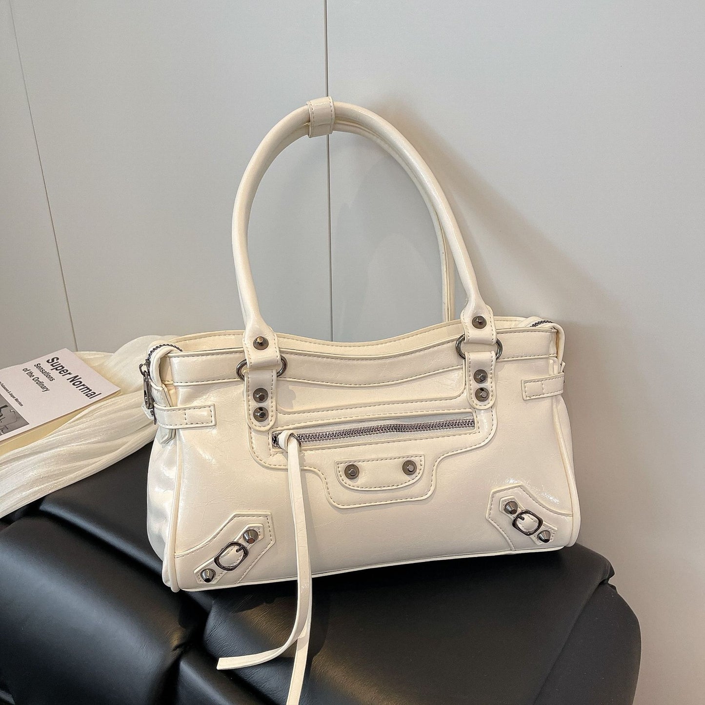 White handbag on a black surface with a neutral background