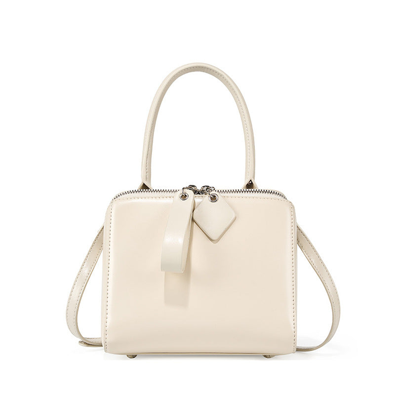 White handbag with a strap on a white background