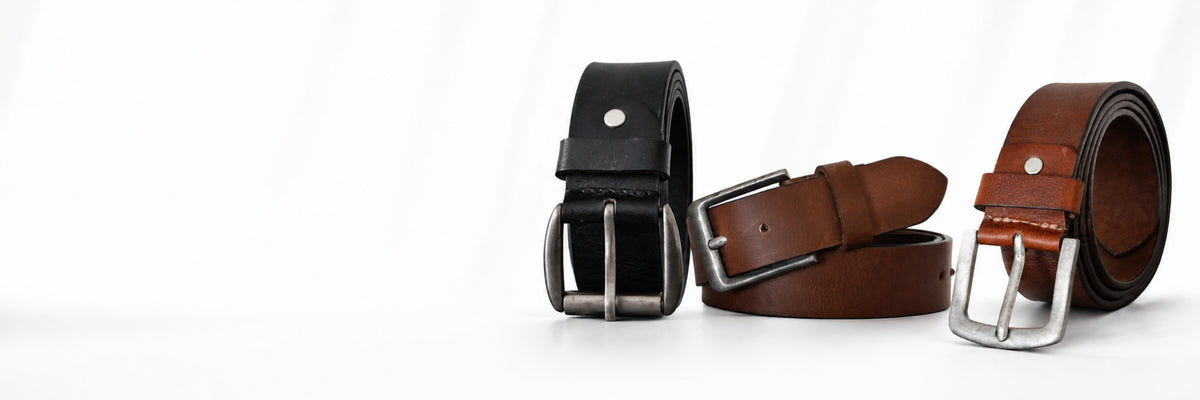 Premium genuine leather belts for men in brown and black colors displayed on a luxury marble background – Yousha Elia handcrafted leather accessories